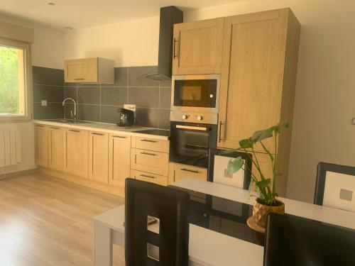 une cuisine avec une table et une cuisinière four supérieur dans l'établissement Gite chez Carolanne et Julien, à Courtivron