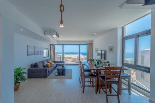 VESTA - Soma Bay Residence في الغردقة: غرفة معيشة وغرفة طعام مع طاولة وكراسي