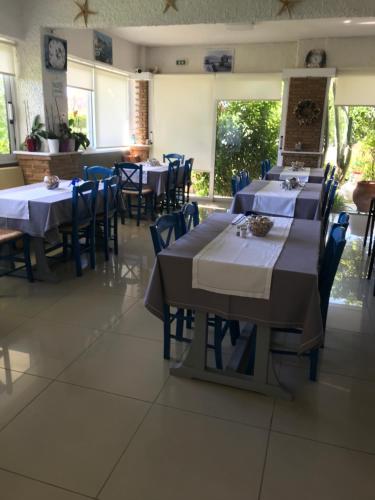 a dining room with tables and chairs in a restaurant at Chaliotis Apartments in Lefkandi Chalkidas