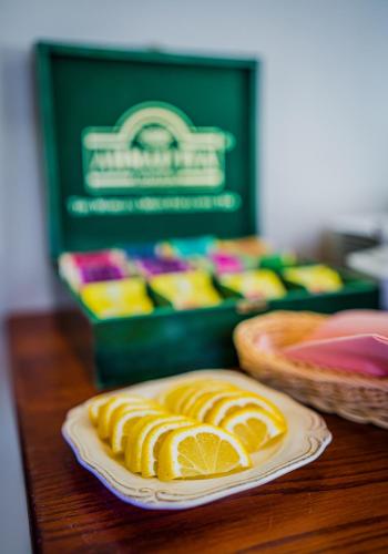 a table with a plate of orange slices and a box of cookies at GLAMOUR - Restaurant & SPA in Przeźmierowo