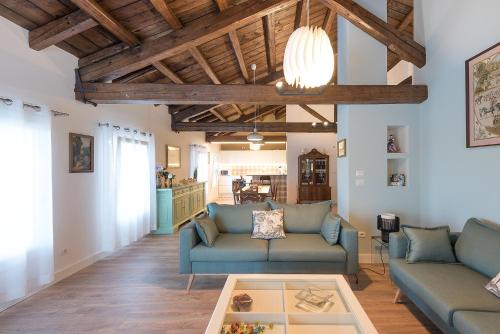 a living room with two blue couches and a table at Barchessa Rossetti in Concordia Sagittaria
