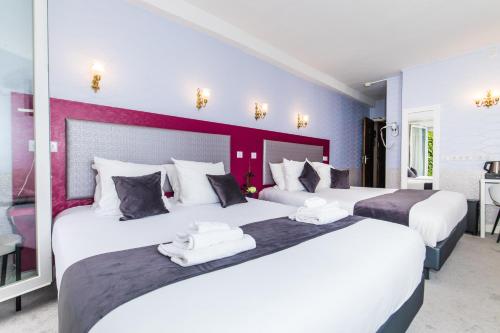 Dos camas en una habitación de hotel con blanco y púrpura en HOTEL DE PARIS MONTPARNASSE en París