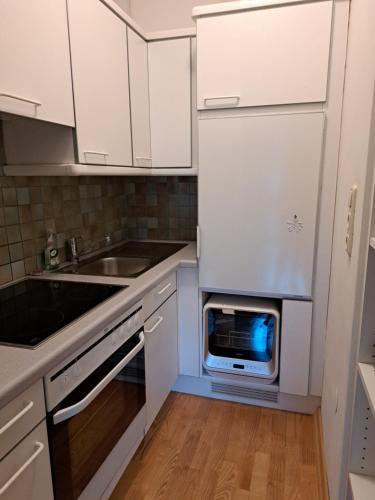 a kitchen with white cabinets and a microwave at Studio-Appartement Drei Hörndl in Bad Hofgastein