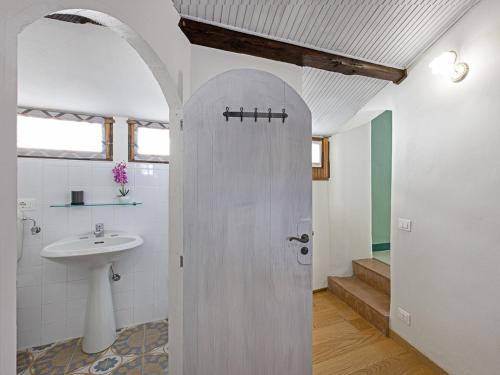 a bathroom with a sink and a toilet and a door at Casa Cecilia in Santo Stefano Belbo