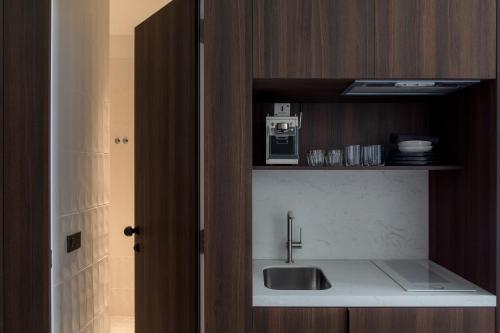 eine Küche mit einer Spüle und einer Mikrowelle in der Unterkunft Bona Fide Main Square Designer Apartments in Zagreb