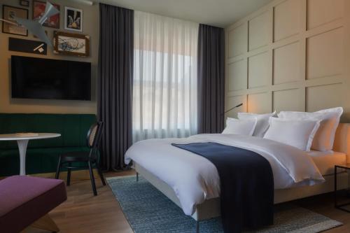 ein Hotelzimmer mit einem großen Bett und einem Tisch in der Unterkunft Bona Fide Main Square Designer Apartments in Zagreb
