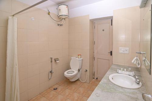 a bathroom with a toilet and a sink at Singrauli Palace Heritage Hotel in Saipur
