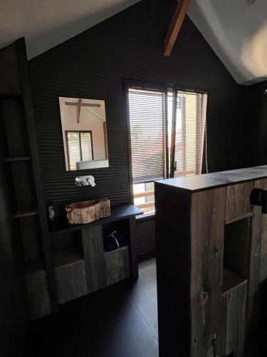 - une salle de bains noire avec un comptoir et un miroir dans l'établissement Le cache a l eau, au Pouliguen