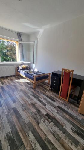 een kamer met een bed, een bureau en een raam bij Ferienwohnung Nordhausen in Nordhausen