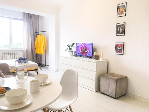 a white living room with a table and chairs at ADT apartments in Almaty