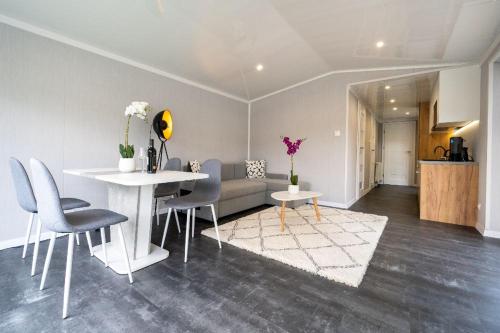 a living room with a couch and a table and chairs at Recreatiepark Maas en Bos in Wellerlooi