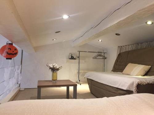 une chambre avec un lit et une table avec un vase de fleurs dans l'établissement Coquet appartement dans mazet Ste Maxime Riviera, à Sainte-Maxime