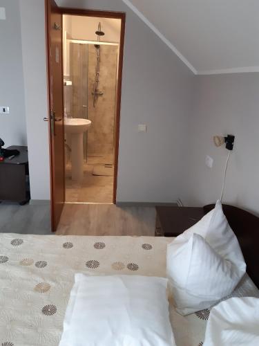 a bedroom with a bed and a bathroom with a sink at Pensiunea Tisa in Baile Felix