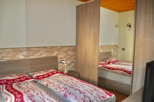 a bedroom with two beds and a mirror at Appartamento 1 Baita Sosio Livigno in Livigno