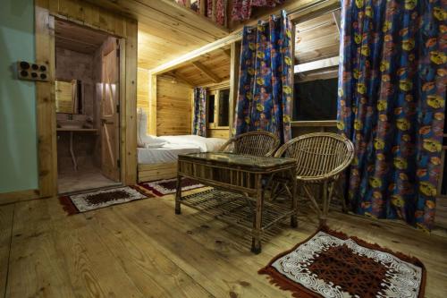 una habitación con 2 sillas y una mesa en una cabaña en Mid Conifer Cottage, en Dalhousie