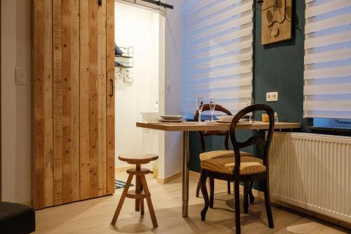 uma pequena cozinha com mesa e cadeiras num quarto em Le Studio Émeraude - Topdestination-Spa em Spa