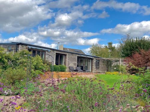 a stone house with a garden in front of it at Meadow Barn in Hereford