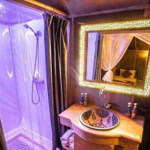 a bathroom with a sink and a shower with a mirror at Desert Lover's Luxury Camp in Merzouga