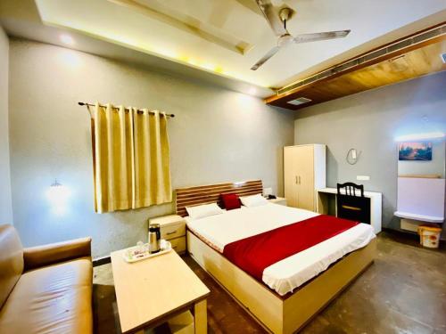a bedroom with a large bed and a couch at Hotel Prayag in Allahābād