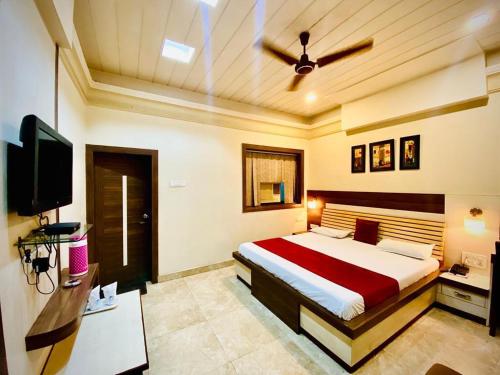 a bedroom with a bed and a ceiling fan at Hotel Prayag in Allahābād