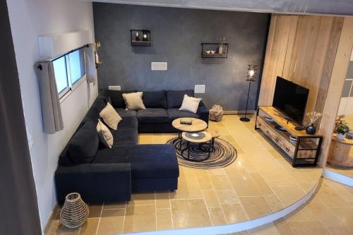 a living room with a couch and a tv at Maison avec piscine pour 10 adultes et 8 enfants ou ados 