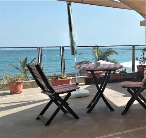 um pátio com uma mesa e cadeiras e o oceano em Apartamento con encanto en la playa frente al mar "Posada Rent House" em Puerto del Rosario