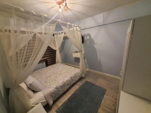 a bedroom with a bed with a mosquito net at BEYAZEV BUTİK OTEL MAŞUKİYE in Kartepe