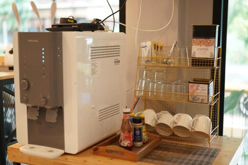 a microwave sitting on top of a counter with dishes at Chillax Khaosok Hostel - SHA Certified in Khao Sok