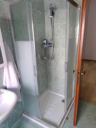 a shower with a glass door next to a sink at Creazzo Tree in Creazzo