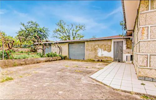 an old brick building with a garage and a driveway at Villa Ginzo in Verín