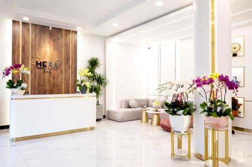 a lobby with a reception desk and flowers at HERA HOSTEL in Chau Doc