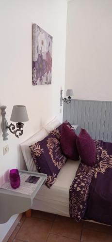 a white couch with purple pillows on it at Le Petit Moulin Tournesol BnB in Sainte-Soline