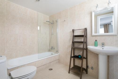 Un baño con inodoro, lavabo y ducha. en Lovely Beachfront Apartment with Panoramic Views, en Altea