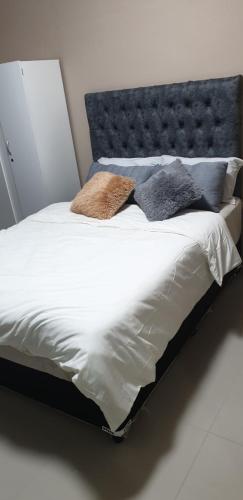 a bed with a blue headboard and pillows on it at PEACE LODGE in Cape Town