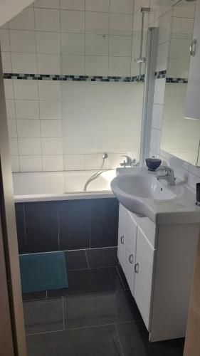 a bathroom with a sink and a tub and a mirror at Schöne Maisonette Düren in Düren - Eifel