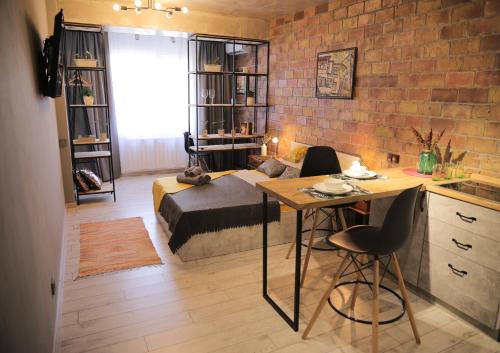 a room with a bed and a table and a kitchen at ADT apartments in Almaty