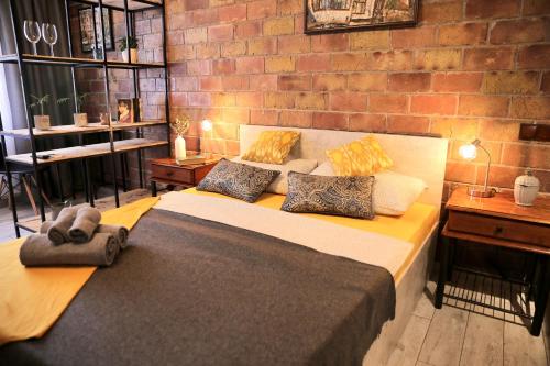 a bedroom with a large bed and a brick wall at ADT apartments in Almaty