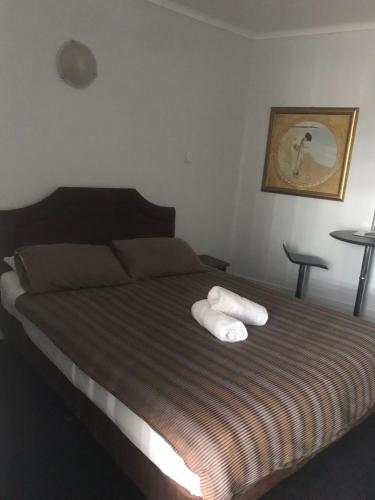 a bedroom with a bed with two white towels on it at The Flinders Hotel Motel Port Augusta in Port Augusta