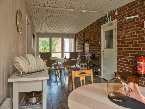 a living room with a table and a brick wall at Herrestad Bed & Guestroom in Värnamo