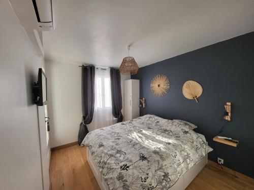 une chambre avec un lit et un mur bleu dans l'établissement Superbe T2 en centre ville au calme à deux pas du marché, à Cavalaire-sur-Mer