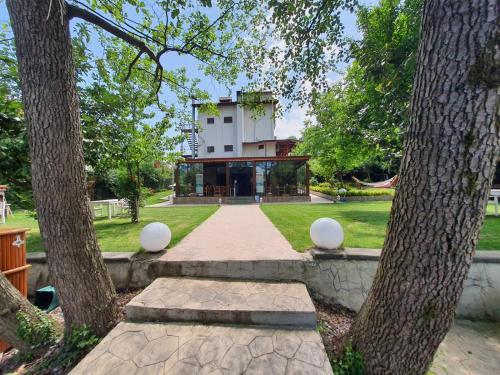 un bâtiment au milieu d'un parc avec deux arbres dans l'établissement BEYAZEV BUTİK OTEL MAŞUKİYE, à Kartepe