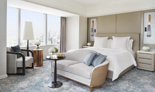 um quarto com uma cama, um sofá e uma cadeira em Four Seasons Hotel Riyadh em Riade