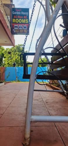 a swing set with a sign in a playground at Tony's Garden House Back Packers inn in Jaffna