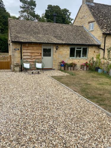 a house with a gravel yard in front of it at Cosy Cotswolds Self-Contained One Bedroom Cottage in Chipping Norton