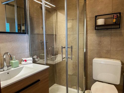 a bathroom with a shower and a toilet and a sink at Chalet aan de Rotte in Rotterdam