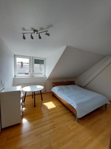 a attic bedroom with a bed and a table at Country Residence near Vienna in Stillfried