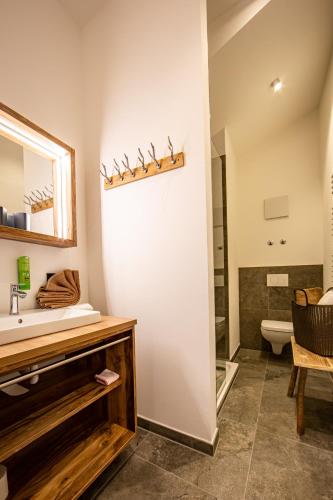 a bathroom with a sink and a mirror at Brunnenhof Oberstdorf - Ferienwohnungen mit Hotel Service in Oberstdorf