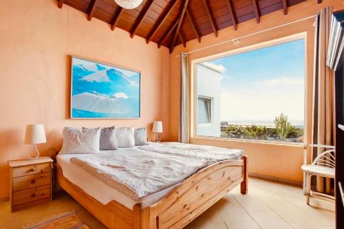 a bedroom with a bed and a large window at Casa Verde in Teguise