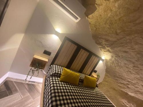 - un salon avec un canapé et des oreillers jaunes dans l'établissement Casa Rural Bajo la Alcazaba, à Setenil de las Bodegas