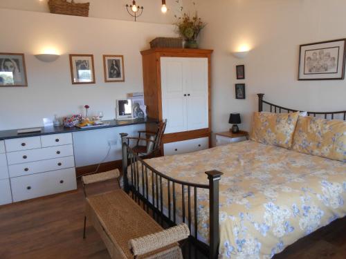 een slaapkamer met een bed en een dressoir bij Callwood Farm Annex Guest Room in Belper